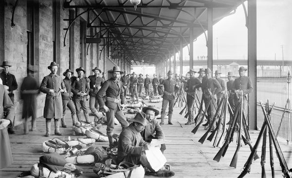 Members of the Colorado Infantry, called to Denver during the City Hall War, sit on a covered walkway at Union Station, March 16, 1894. Courtesy History Colorado Center - Stephen H. Hart Library & Research Center, Harry H. Buckwalter photo, #90.156.1805
