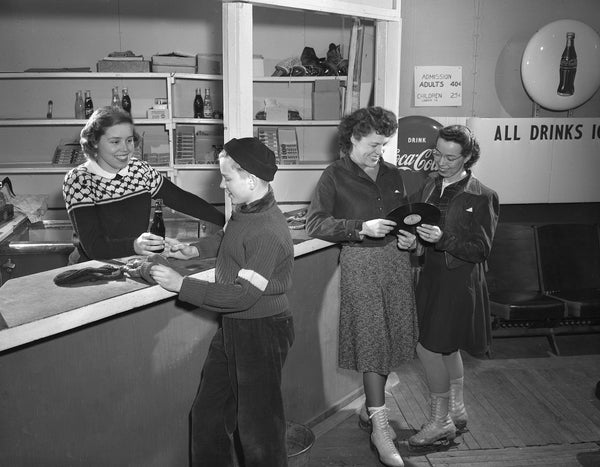 Jane Spencer handing a soda to Peter Weiss while Lucille Madigan and Helen Topp look over the selection of records in the warming room and snack bar at the Madison Figure Skating Club’s new indoor skating arena at Truax Field, January 12, 1949. Courtesy Wisconsin Historical Society, Image ID 56843