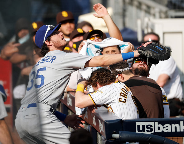 Cody Bellinger reaches over the dugout railing to catch a foul ball in the ninth inning during a regular season game at Petco Park in San Diego. K.C. Alfred / The San Diego Union-Tribune