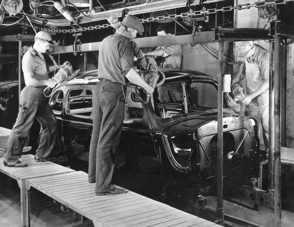 Four workers on an assembly line in the Packard factory polishing a car body, circa 1939. Courtesy Detroit Public Library / #na030005
