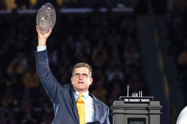 At the Crisler Center, Jim Harbaugh shows off the hardware from a 15-0 season. Perfection improved his bank account by $11.2 million. JUNFU HAN/DETROIT FREE PRESS