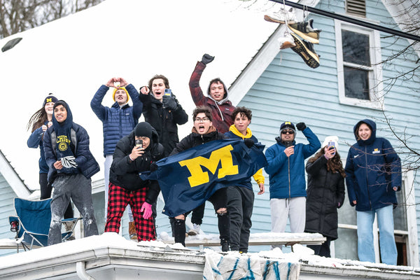 On State Street, Michigan fans take to higher ground for better parade viewing. Attendance was estimated at 50,000 maize-and-blue souls. JUNFU HAN/DETROIT FREE PRESS