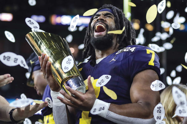 Michigan tailback Donovan Edwards roars with excitement while holding the national championship trophy as confetti footballs fall from the roof of Houston’s NRG Stadium. Edwards, a junior from West Bloomfield, scored touchdowns on his first two touches in the title game against Washington — a 41-yard run with 10:14 left in the first quarter and a 46-yard run with 2:23 left in the same quarter. JUNFU HAN/DETROIT FREE PRESS