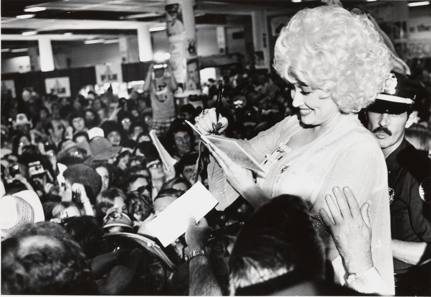 Dolly Parton signing autographs for a crowd of fans