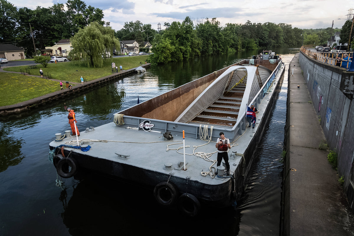 The CMT Kelly barge, pushed by CMT Otter tugboat and carrying a section of the Ralph Wilson Park Bridge, approaches Lock E-24 in Baldwinsville in 2024. Kayla Breen / Syracuse University