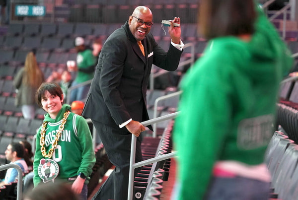 Former NBA and Charlotte 49ers star Cedric Maxwell (center) waves to a Boston Celtics fan as he walks up the stairs at Spectrum Center in Charlotte before an NBA game on Jan. 16, 2023. JEFF SINER / THE CHARLOTTE OBSERVER