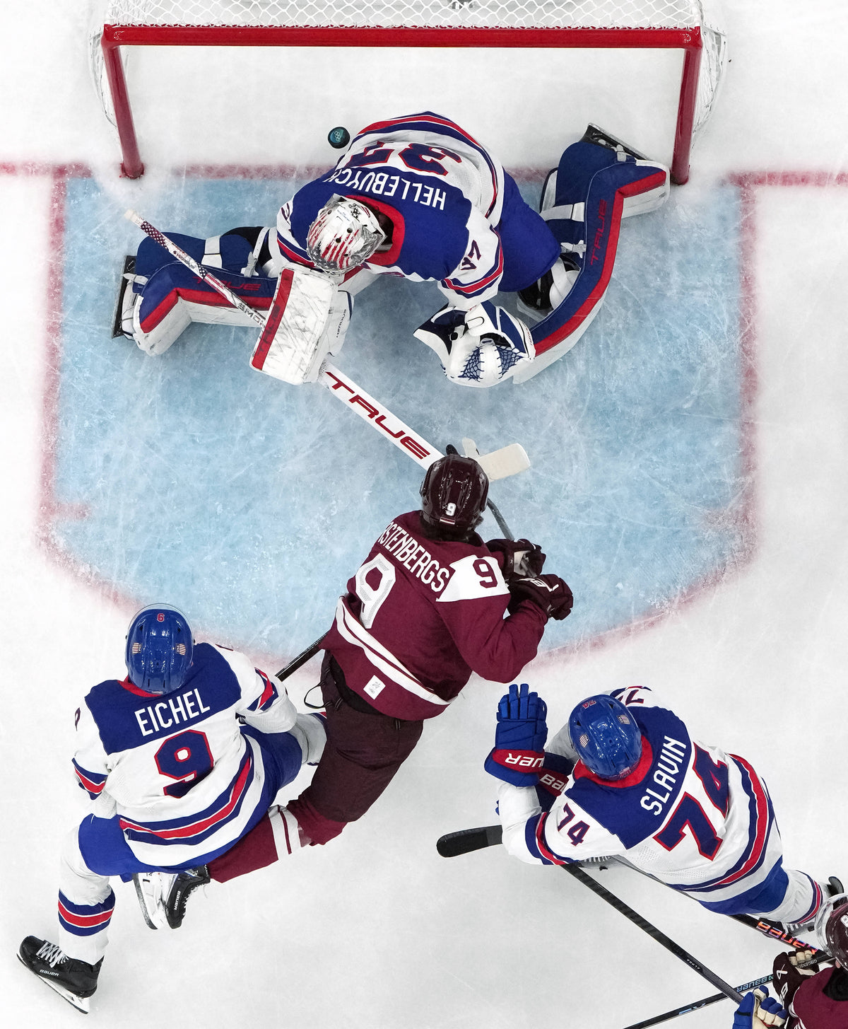 Renars Krastenbergs of Latvia scores their first goal past Connor Hellebuyck of United States in men's ice hockey group C play during the Milano Cortina 2026 Olympic Winter Games at Milano Santagiulia Ice Hockey Arena. David W Cerny / Reuters via Imagn Images