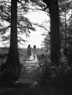 Jean Cox (left) and Mary Elizabeth Bray stepping into the shade of the cypress trees by Lake Phelps as they walk toward the Somerset Plantation, 1938.  Courtesy State Archives of North Carolina, Conservation and Development, Travel Information Division Photograph Collection, 1373