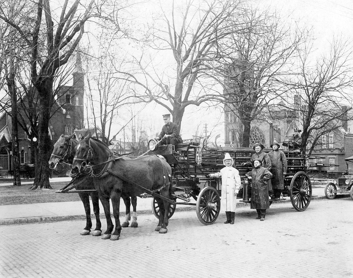 Volunteer fire chief Henry J. Shultz (white coat), driver E. B. Hettinger, and four other men with the first ladder wagon in Ashland, circa 1890. The horses were identified as Frank and Bill. Records indicate that Ashland had a volunteer fire unit as early as 1853. In the late 1880s, the first fire station was built at the corner of Second and Orange Streets. Courtesy Ashland County Historical Society