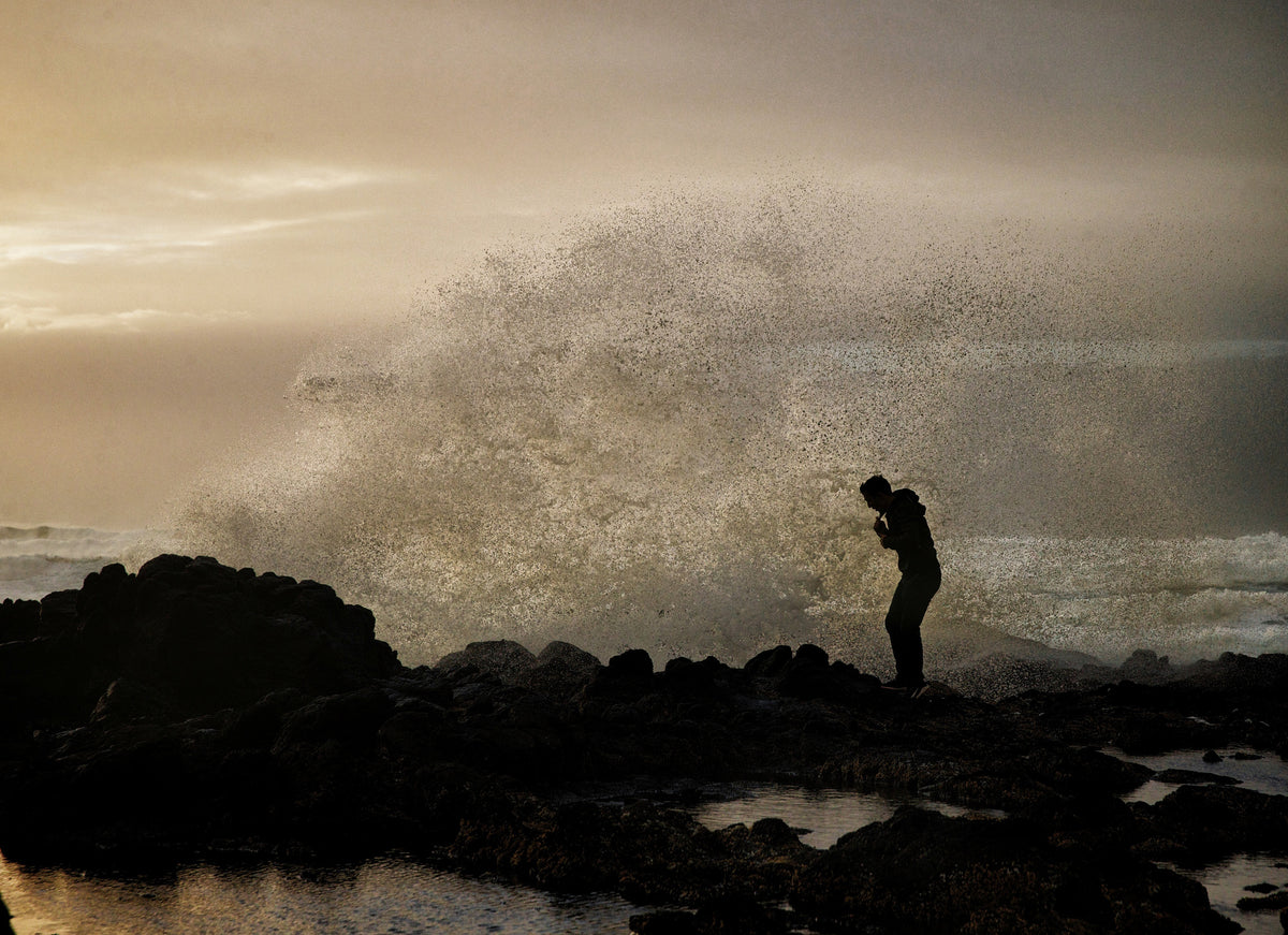A wave crashes into the rocky shore near Cook's Chasm at Cape Perpetua on the central Oregon coast, spraying an onlooker. Strong winter storms often send towering waves over the rocks, part of the cycle of ocean life that feeds tide pools, and carves caves and chasms into the rough volcanic basalt. It's an awe-inspiring sight for tourists, but the strong waves can also knock people down across barnacle-crusted rocks, dragging them into the turbulent ocean. Courtesy Thomas Boyd/The Oregonian