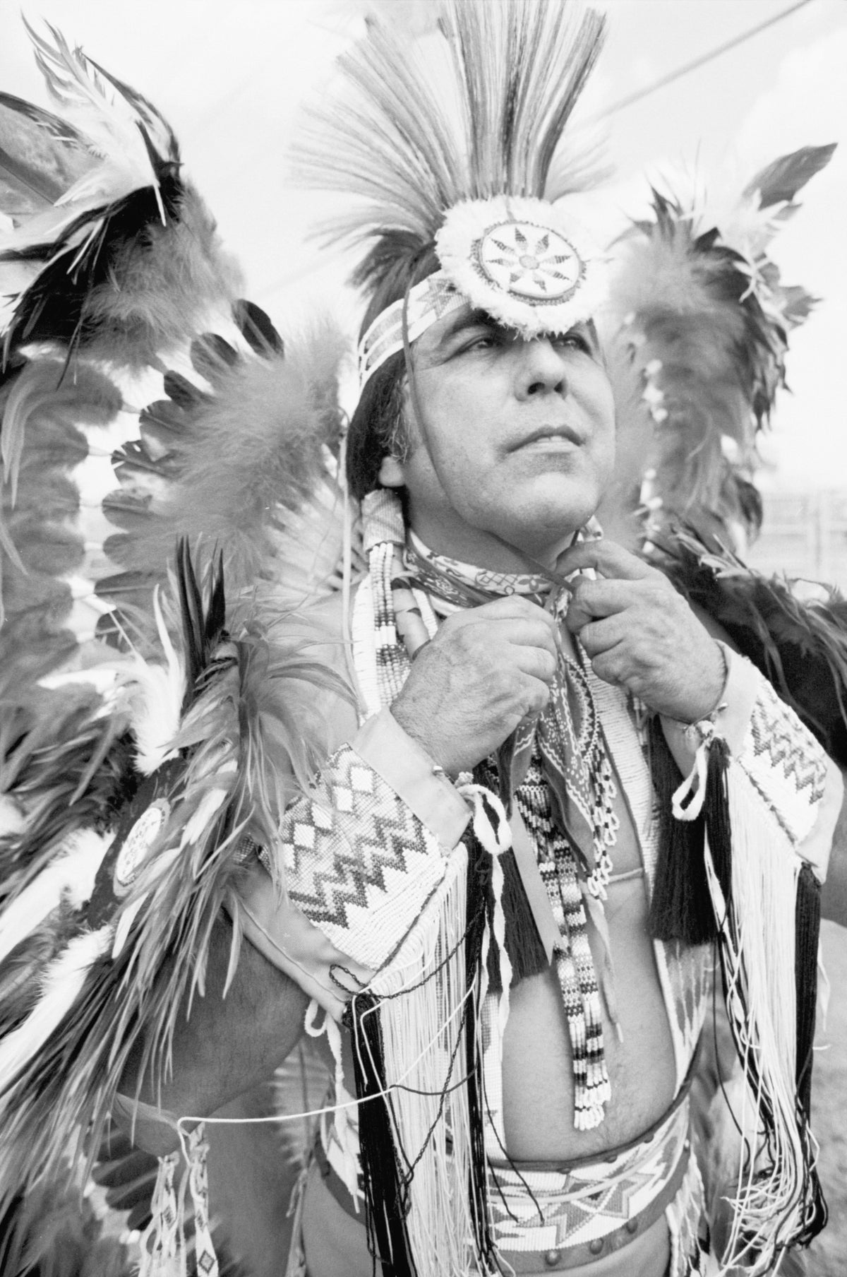 Vincent Pocowatchit, a Comanche from Cyril, Oklahoma, putting on his headdress before dancing in the opening procession for the 1982 National Championship Pow-Wow in Grand Prairie, September 11, 1982. Courtesy Fort Worth Star-Telegram Collection, Special Collections, UT Arlington Libraries; photo by Rodger Mallison