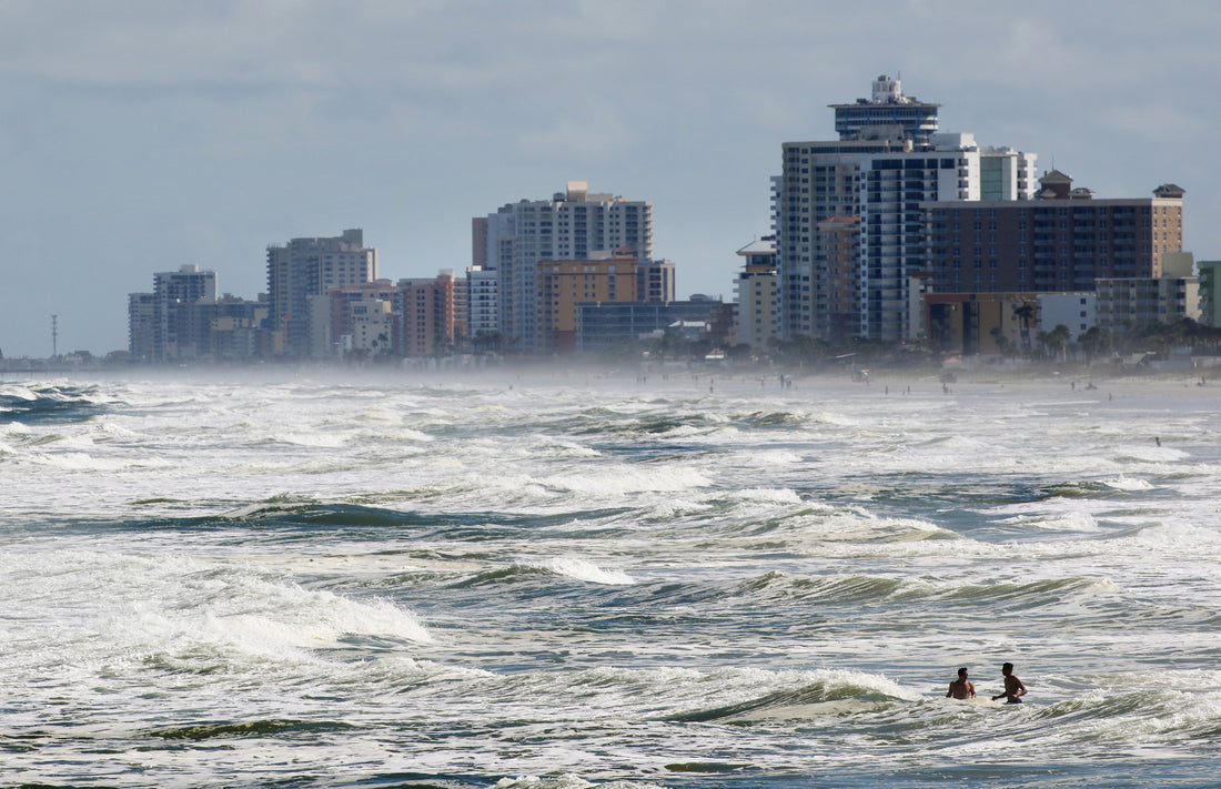 A pair of beachgoers bob in the swelling surf in Daytona Beach as Hurricane Matthew approaches Volusia and Flagler counties. News-Journal/Nigel Cook