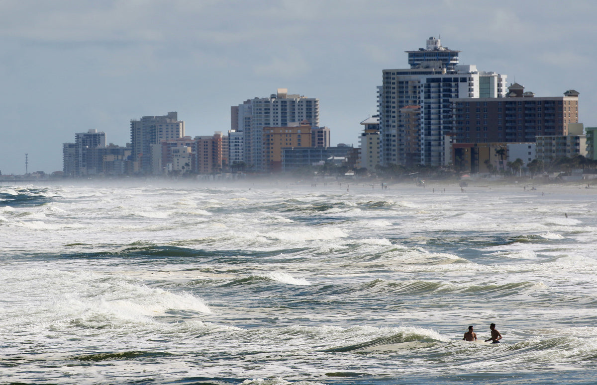 A pair of beachgoers bob in the swelling surf in Daytona Beach as Hurricane Matthew approaches Volusia and Flagler counties. News-Journal/Nigel Cook
