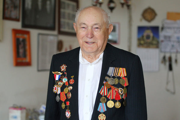 Belrus native Leonid Pollack, above, and in inset photo, top left, displays some of his medals at his home in Williamsville. He became a U.S. citizen in 1996.
