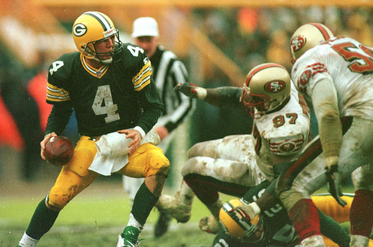 Brett Favre scrambles away from an oncoming San Francisco 49ers' Bryant Young (97) during the Jan. 4, 1996, NFC divisional playoff game. The Packers won 35-14. File/PackersNews.com