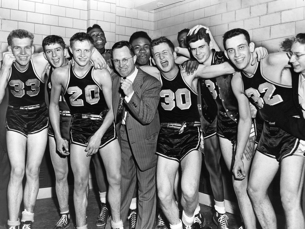 Leading the Vikings in a locker-room cheer for the newly crowned City Series champion North High School are Bill Willgohs (33), Ned Randall (20), basketball coach Bob White, Tony Vinciguerra (30), Dick Rodeman, and Glenn Stockton (32), Akron, February 21, 1951. North beat South 52-38 in the title game to win its first championship since 1944. Courtesy Akron Beacon Journal