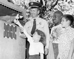 "Sparky" the Fire Department puppet shakes hands with five-year-old Janice Antoszczyk, while  Detroit Police Inspector Ray Strand and other kids of Detroit News Day Camp look on, July 8, 1953. The Detroit News