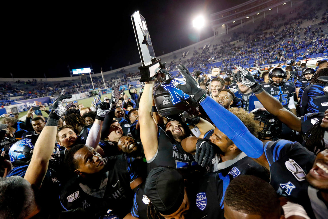 Memphis players hoist the AAC West championship trophy after defeating Cincinnati 34-24 on Nov. 29, 2019, at Liberty Bowl Memorial Stadium in Memphis. Courtesy Max Gersh / The Commercial Appeal
