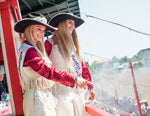 Lady-in-waiting Savannah Messenger, left, and Miss Frontier Bailey Bishop point to and smile at fans inside Frontier Park Arena during the Cheyenne Frontier Days Rodeo. Rhianna Gelhart / For the Wyoming Tribune Eagle