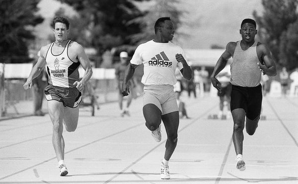 Michael Bates gives a grin to former UA football teammate James Bullock at the 40-yard dash finish line in the Willie Williams Classic, March 20, 1993. Courtesy Linda Seeger / Arizona Daily Star