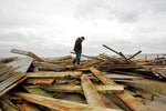 Edy Pagoda phones a friend to talk about the Boardwalk in Atlantic City as he stands amid what’s left of it. Noah K. Murray / The Star-Ledger