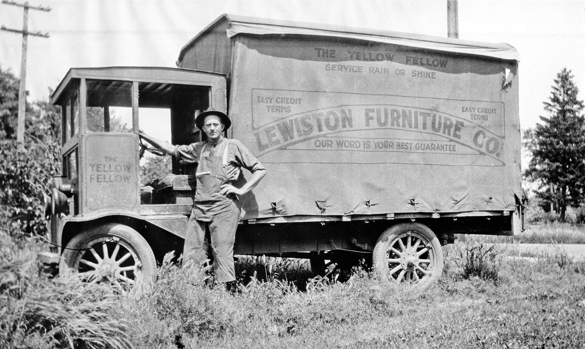Levi Lawson Allen standing next to "The Yellow Fellow" Lewiston Furniture Co. truck, circa 1915. Courtesy HS 91-28-1