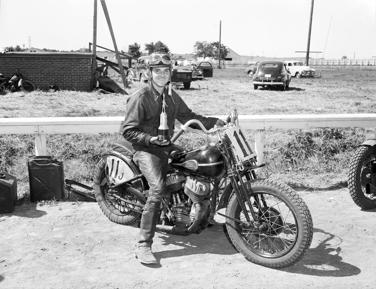 A winning motorcyclist, thought to be Billy Wolff, proudly displays his trophy at the Nebraska State Fairgrounds on July 6, 1947. Courtesy Nebraska State Historical Society / #RG2183.PH001947-000706-9