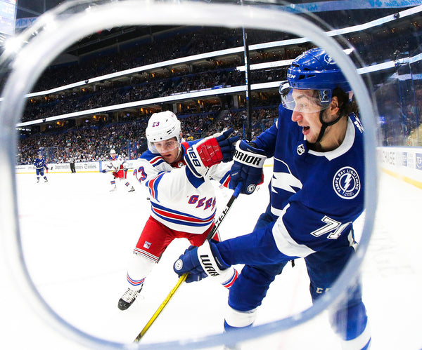 Pictured through the photo hole, Tampa Bay Lightning center Anthony Cirelli (71) battles along the glass against New York Rangers defenseman Adam Fox (23) during first-period action on Nov. 14, 2019, in Tampa. Tampa Bay Times / Dirk Shadd