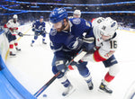 Tampa Bay Lightning center Brayden Point (21) works to move the puck along the boards against Florida Panthers center Aleksander Barkov (16) in game four of the first round of the NHL Stanley Cup Playoffs at Amalie Arena on May 22, 2021, in Tampa. Dirk Shadd / Tampa Bay Times