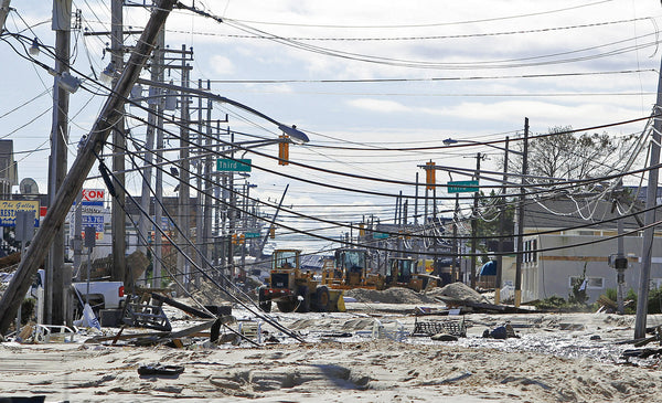 Route 35 north in Ortley Beach is covered in sand and debris as crews weave between power lines to begin cleaning up. Saed Hindash / The Star-Ledger