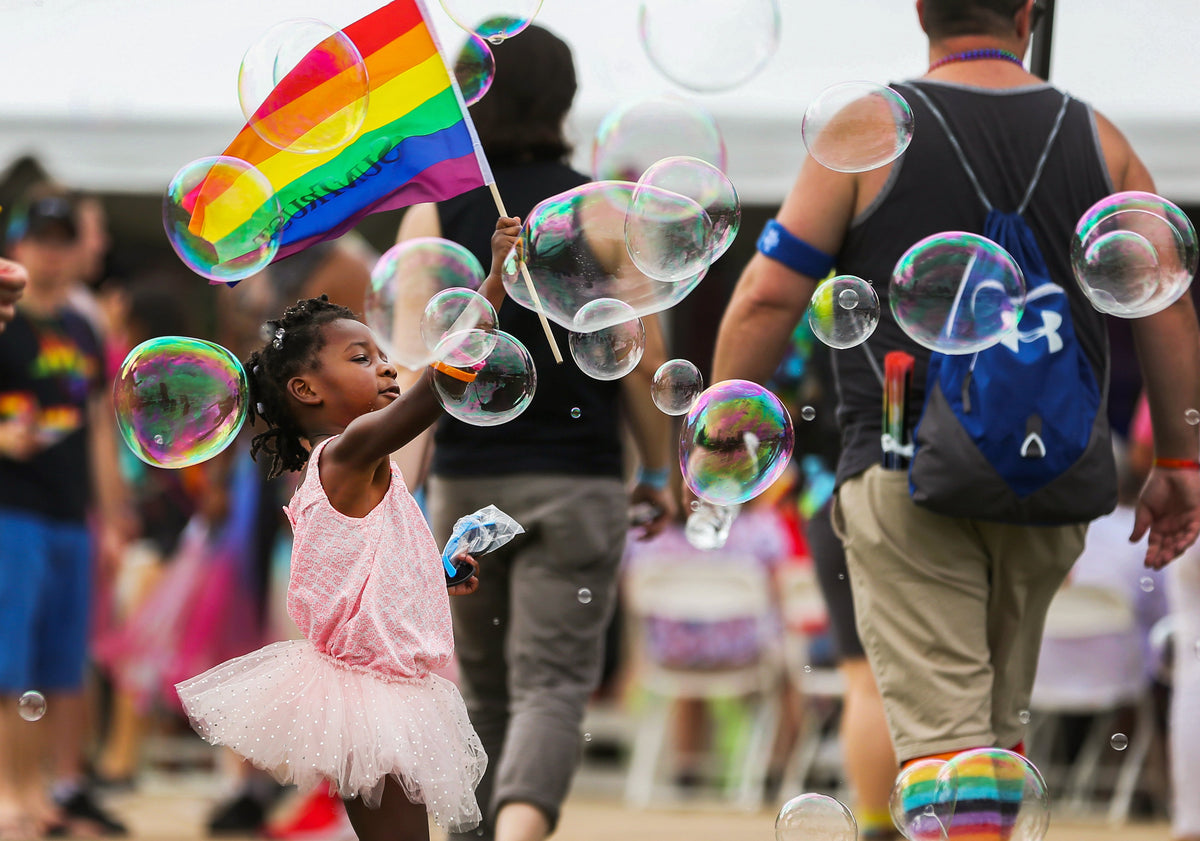 Bria Edmonds, three, of Richmond running with a rainbow flag at Virginia PrideFest on Brown’s Island, September 22, 2018. Courtesy Richmond Times-Dispatch
