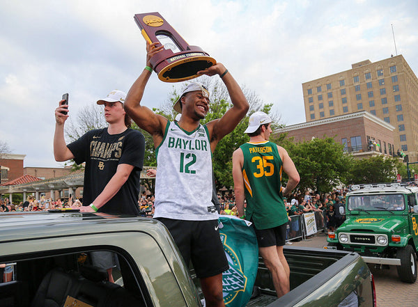 Baylor guard Jared Butler holds the NCAA championship trophy as he and his Bears teammates make their way down Austin Avenue during a parade to mark their national championship win, a first for the Baylor men's basketball team. Courtesy Jerry Larson / Waco Tribune-Herald