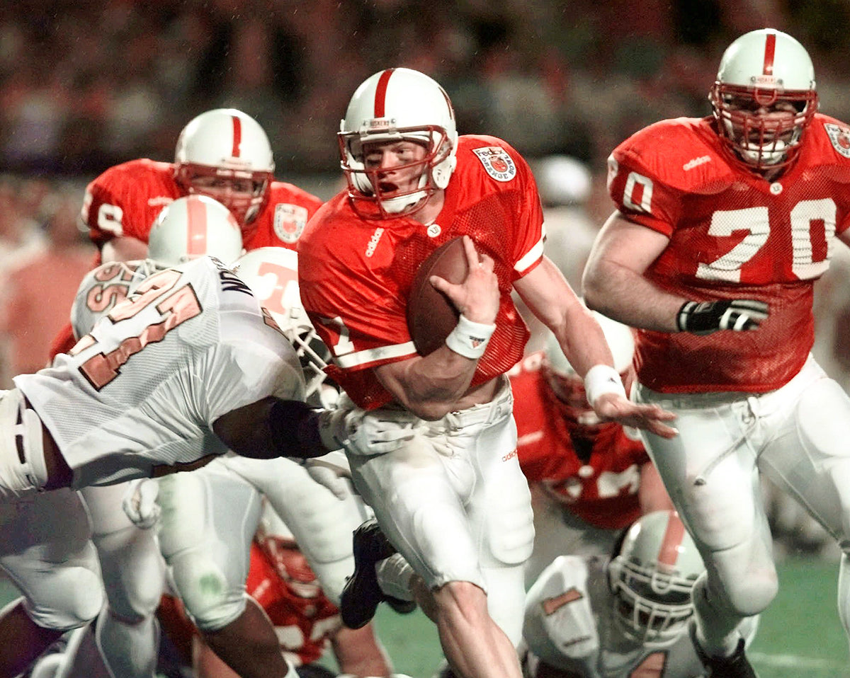 Scott Frost tries to get past Tennessee defender Al Wilson (27) as Nebraska’s Eric Anderson (70) follows the play during second-quarter action in the Orange Bowl. Courtesy AP