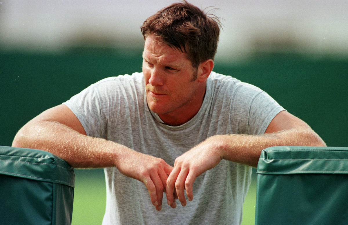 Quarterback Brett Favre leans on a blocking sled after running wind sprints.