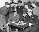 Mrs W. Bartlett Summer, president of the Buffalo Travelers' Aid Society, provided the new information center in 653 Main Street which was a haven for all service men, March 1942. Standing from left: Sergeant Edward Nappen, Mrs. Horace Beecher, Yeoman Herbert K. Chamberlain, U.S.N. Corporal Allen G. Sexton, Signal Corps, Mrs. Sumner. Sitting from left: Private Albert J. Kamyk, Mr. Richard W. Callen, first class seaman, Mr. Joseph L. Musial, apprentice seaman. Courtesy Buffalo News archives