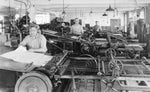 Frank J. Mocny, a journeyman pressman, is seen in the middle of the photograph working in the press room at W. Hazleton Smith, 1930. The business was located at 37 Franklin St. and the employees were working on Regents papers. Audrey Rubino