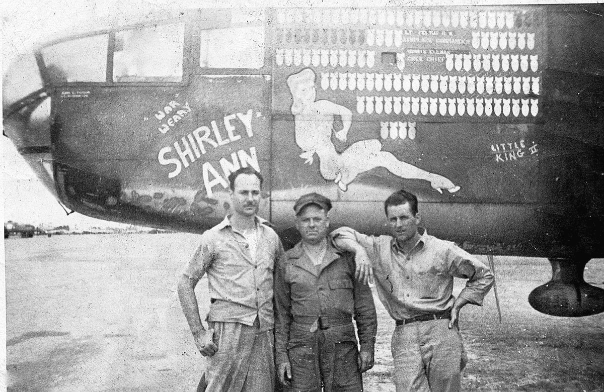 Three men pose in front of a war-weary B25 bomber, "Shirley Ann," at the U.S. Army Air Base in Laurel, circa 1946. The man in the middle is identified as Curtis Parker.