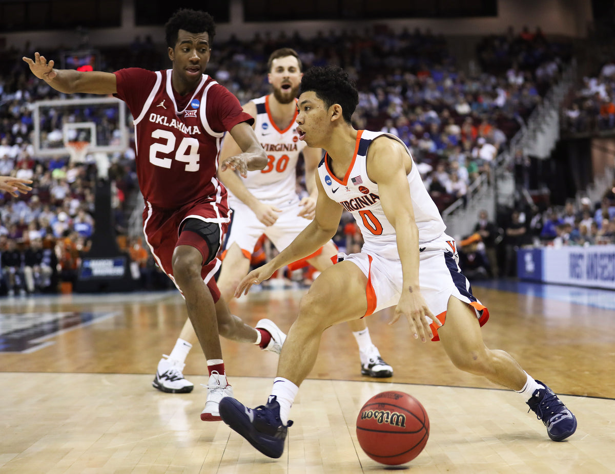 Virginia guard Kihei Clark (0) drives past Oklahoma's guard Jamal Bieniemy (24) in the first half. Courtesy Zack Wajsgras/The Daily Progress