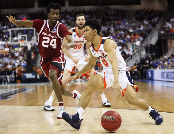 Virginia guard Kihei Clark (0) drives past Oklahoma's guard Jamal Bieniemy (24) in the first half. Courtesy Zack Wajsgras/The Daily Progress