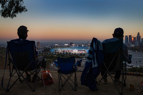 Left: Talk about sitting in the last row. Keith Hupp, left, and David Lopez look at Dodger Stadium, and maybe see some action, from a spot in Elysian Park during a game. But, they could follow on the radio. No fans were allowed in the Stadium this season. Gina Ferazzi / Los Angeles Times