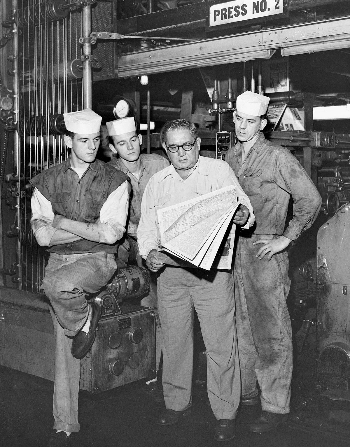 Plain Dealer employees in the press department including Frank Kerbers, holding the newspaper, September 1957. Courtesy Cleveland Public Library Photograph Collection/#SCL011265