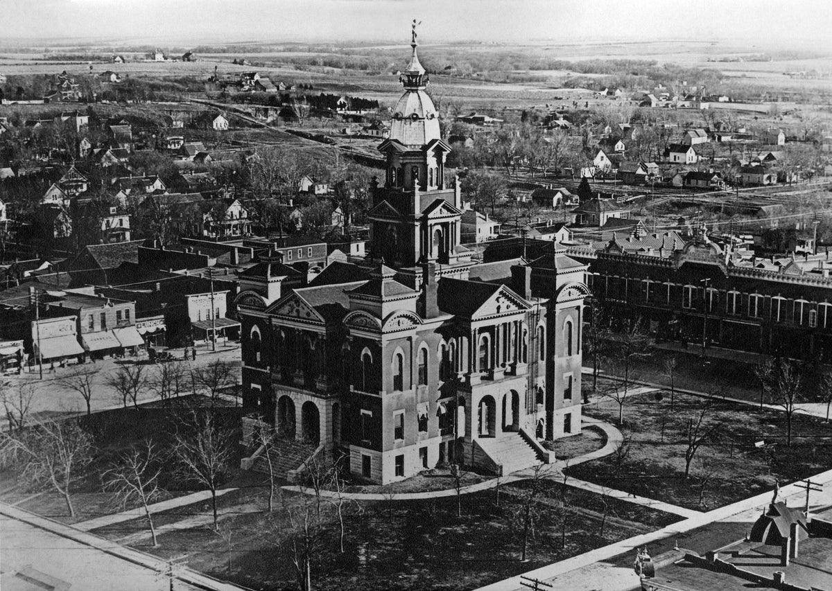 This is a bird’s-eye view of the square, looking at the courthouse. This photo was taken from the northwest corner looking southeast, before the downtown was paved.
