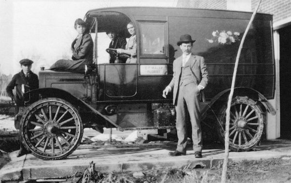 C. F. Maler Florist delivery truck at 3914 West Twenty-Ninth Avenue, circa 1920. Maler is standing by the toolbox on the running board and his wife, Josephine, is at the wheel. He started the company in 1911 and invented a steel-studded durable tread tire cover, which was used to protect the fragile tires of that decade. Courtesy J. F. Maler
