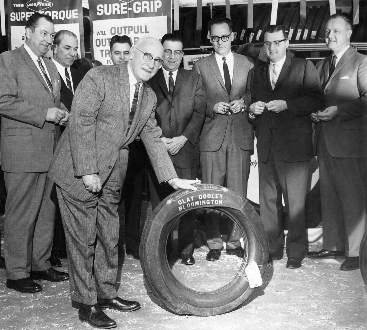Clay Dooley showing off a tire at his repair shop, February 12, 1965. Courtesy The Pantagraph
