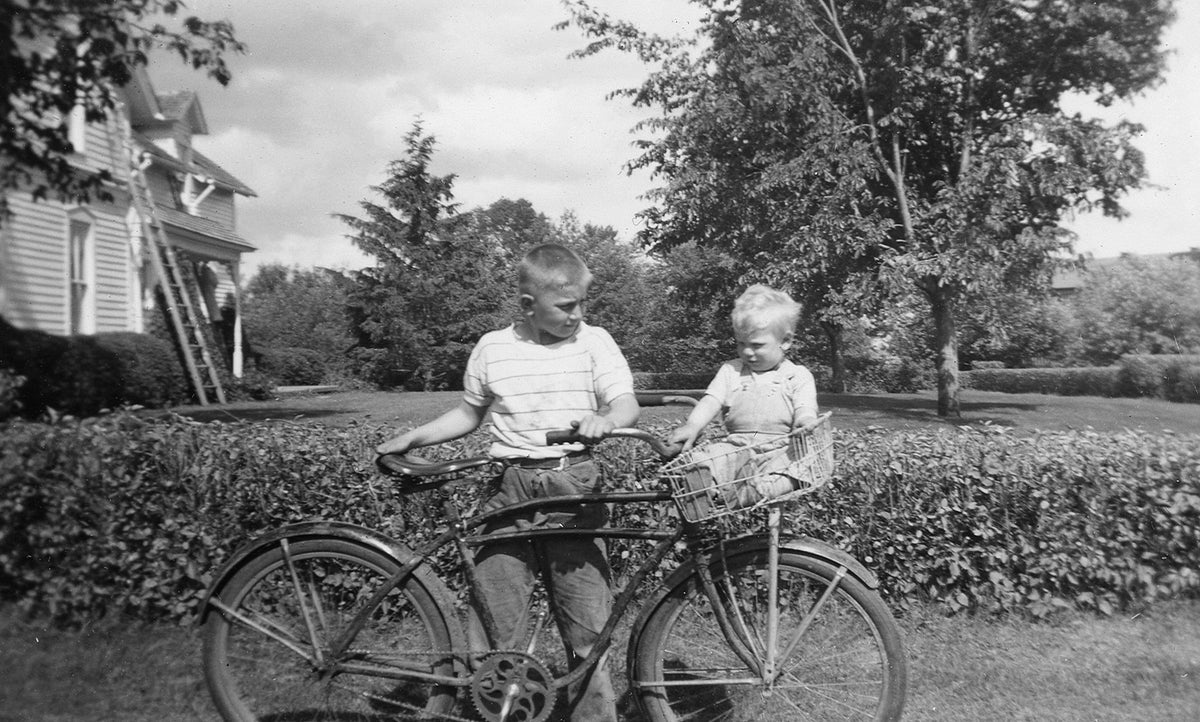 Kenny Derner holding a bicycle and Ed Derner sitting in the basket, June 9, 1951. Courtesy Nicollet County Historical Society