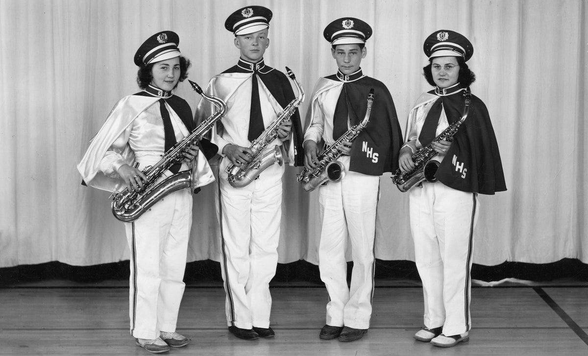 Four saxophone players of the Nicollet, MN High School Band wearing their new white band uniforms with dark blue capes & hats; 1942. L to R are: Nourie, Delores/Wilking, James/ Stolz, Charles/Nourie,Gertrude. Couresty Nicollet County Historical Society