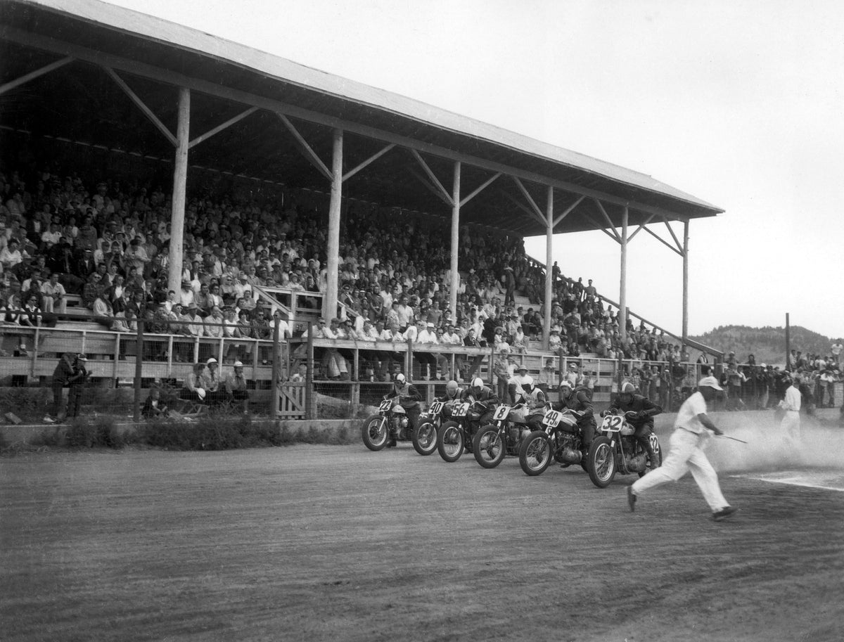 Motorcycle racers speed off from the starting line during an early year of the Black Hills Motorcycle Classic in Sturgis.  ^^ left light rgba(20,20,20,0)