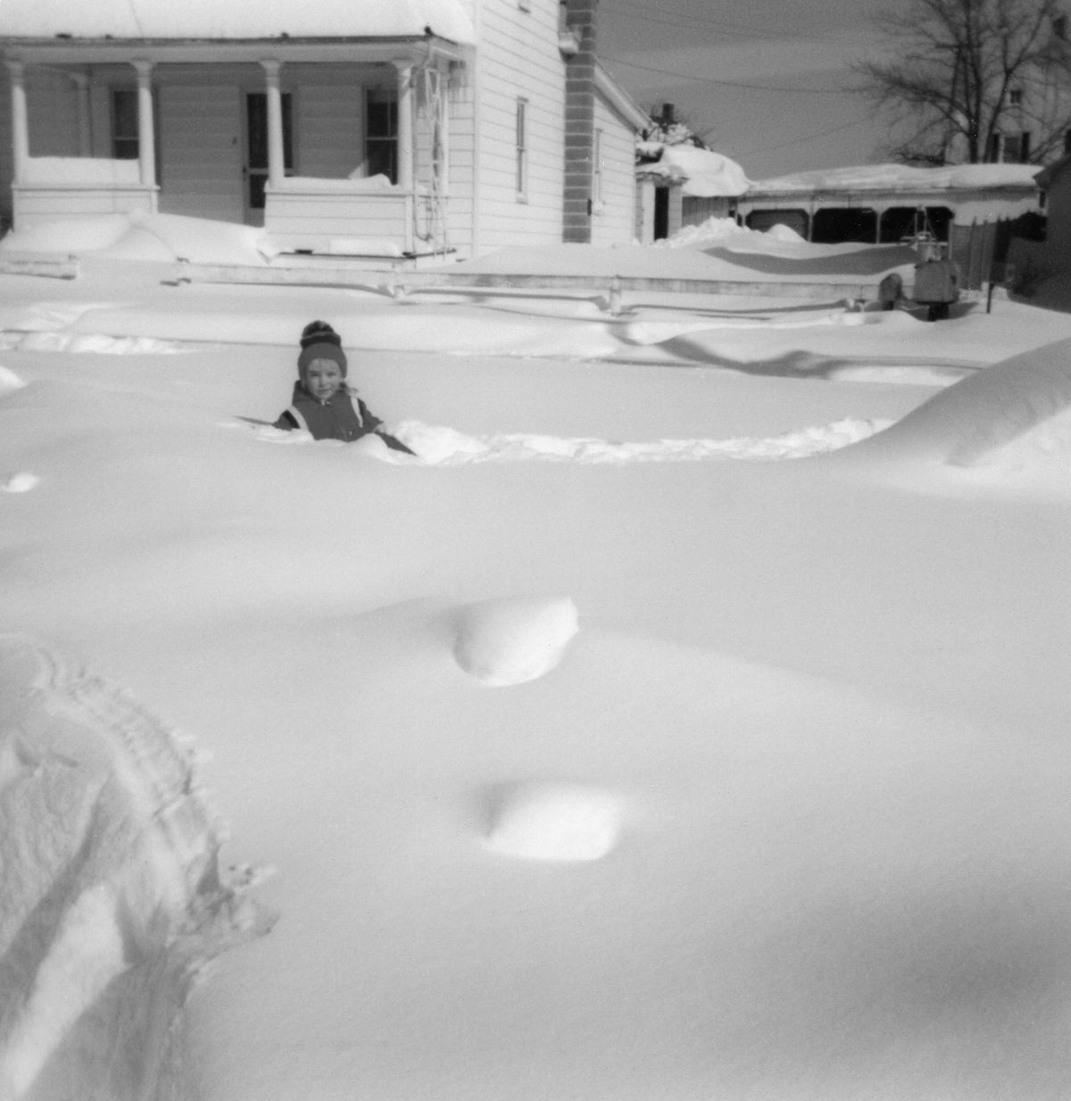 Five-year-old Amy Faith Schaeffer stands in several feet of snow in her front yard following The Blizzard of 1983 at 836 Bedington Road, Bedington. The mound on the right in the photo is the family car. Phil Martin