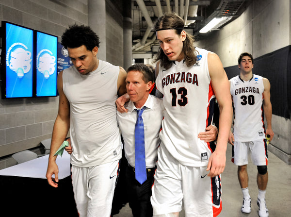 Gonzaga coach Mark Few walks arm-in-arm with players Elias Harris and Kelly Olynyk, with Mike Hart trailing, after losing to Wichita State in their third-round NCAA Division 1 Men’s Basketball Championship game, March 23, 2013, at the EnergySolutions Arena in Salt Lake City. Dan Pelle / The Spokesman-Review