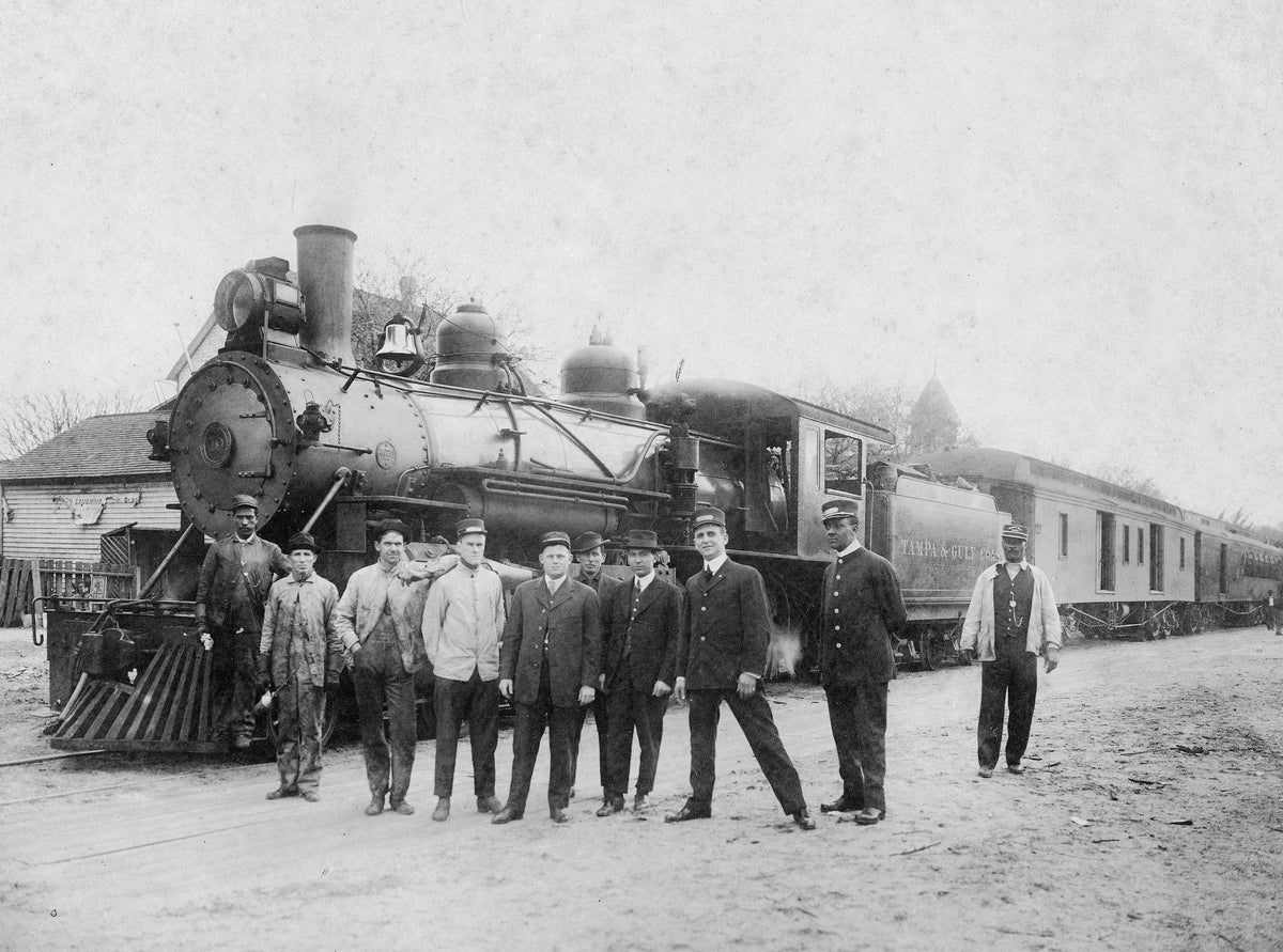 New engine, early 1900s. Leslie Raulerson (in white coat) was either a flagman or expressman. Conductor Charlie Furman is also included. Courtesy Matheson History Museum ^^ center light rgba(0,0,0,.3)